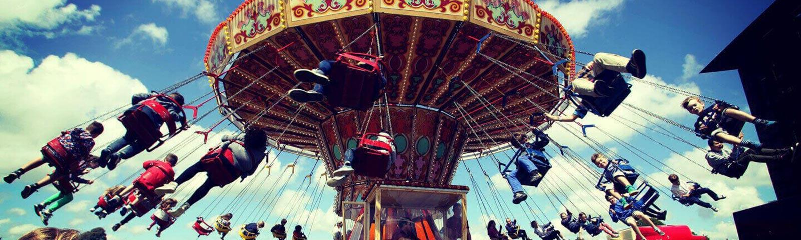 Kids sitting on a fun fair ride at an family event at Fontwell Park Racecourse.