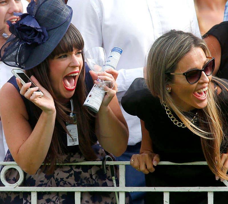 Two ladies cheering on while at the races  at Fontwell Park Racecourse.